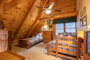 a log cabin bedroom with a bed and a ceiling fan at Apple Cove in Vilas