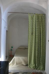- une chambre avec un lit et un rideau vert dans l'établissement Rustic Liguria, à Ceriana
