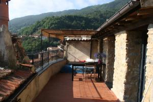 Rustic Liguria في Ceriana: بلكونه مع طاوله واطلاله على جبل