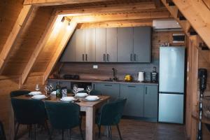 a kitchen with a table with chairs and a refrigerator at Blidinje Lake House in Blidinje