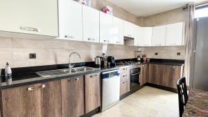 a kitchen with white cabinets and a sink at Serenity - Appart Piscine - 4-5p in Agadir
