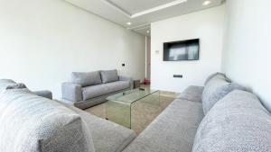 a living room with a couch and a glass table at Serenity - Appart Piscine - 4-5p in Agadir