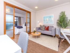 una sala de estar con un sofá y una cama en Cozy Central Apt with Pool & Gym by Zodiak Stays, en Auckland