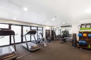 un gimnasio con varias cintas de correr y máquinas en él en Cozy Room with King Bed, Gym and Pool Zodiak Stays, en Auckland