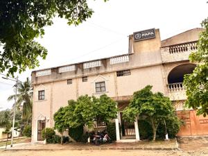 a building with a motorcycle parked in front of it at Residence Fafa in Totigan +8 photos