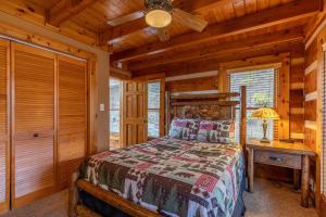 Un dormitorio con una cama en una cabaña de troncos en Ambleside, en Vilas