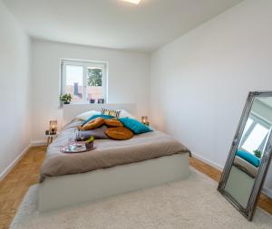 Un dormitorio con una cama grande con espejo. en OG2 Rechts 2-Zimmer Wohnung mit Balkon 15min bis Salzburg, en Freilassing