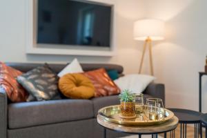 sala de estar con sofá con almohadas y mesa en OG2 Rechts 2-Zimmer Wohnung mit Balkon 15min bis Salzburg, en Freilassing