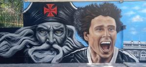 a wall with a painting of a man wearing a hat at Colinna Hostel in Rio de Janeiro