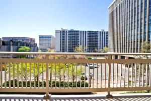 Addison HeightsにあるSpacious Apt in Arlington W Fitness Centerの木製ベンチ付きのバルコニーから市街の景色を望めます。