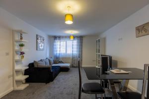 a living room with a couch and a table at Central Luton Ground Floor Flat Sleeps 4 in Luton