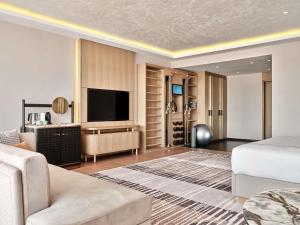 salon z łóżkiem i telewizorem z płaskim ekranem w obiekcie Swissotel Tashkent w Taszkiencie