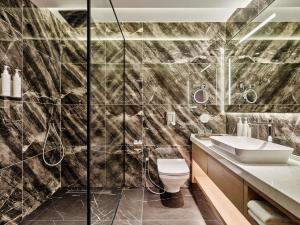 łazienka z prysznicem, toaletą i umywalką w obiekcie Swissotel Tashkent w Taszkiencie +22 zdjęcia