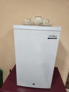 a white refrigerator with two cups on top of it at Al Lado Del Movistar Arena in Santiago
