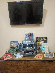 a table with books and a tv on top at Al Lado Del Movistar Arena in Santiago
