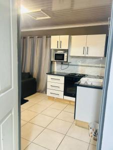 a kitchen with white cabinets and a stove top oven at Richards Bay Serenity Retreat Apartments in Richards Bay