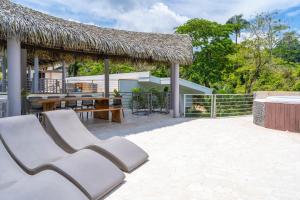 a patio with chairs and a thatch roof at Hermosa Wave B2 in Pochotal