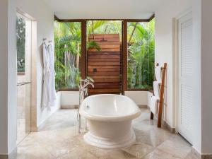 a bathroom with a white tub and a large window at Fairmont Mayakoba in Playa del Carmen