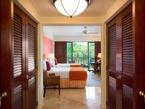 a bedroom with a bed and a balcony at Fairmont Mayakoba in Playa del Carmen