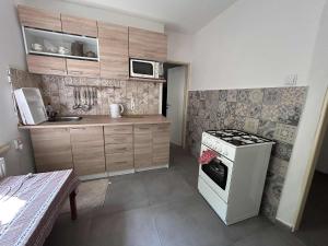 a small kitchen with a stove and a microwave at Chata Jizerky in Polubný