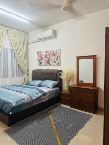 a bedroom with a bed and a mirror at Homestay Tchr azie in Kuantan