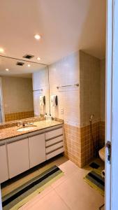 a bathroom with two sinks and a mirror and a toilet at Unidade Autonoma 609 em Villa Del Sol in Rio de Janeiro