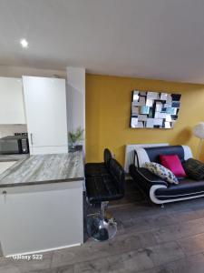 a kitchen with a counter and two chairs and a couch at Blue Haven 2 in Manchester