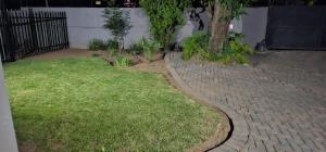 a yard with a tree and a brick sidewalk at Executive Suite in Vanderbijlpark