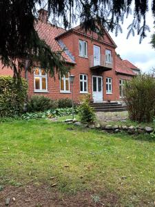 a large red brick house with a grass yard at Pine Haven in Odense