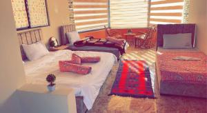 a bedroom with two beds and a couch at Sami Rum Mountains in Wadi Rum