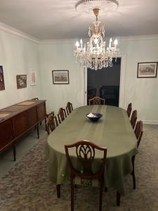 Un comedor con una mesa con sillas y una lámpara de araña. en Pine Haven, en Odense