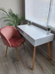 オッソンヌにあるStudio independent à 500m du MEETTの窓の横にある白い机と赤い椅子