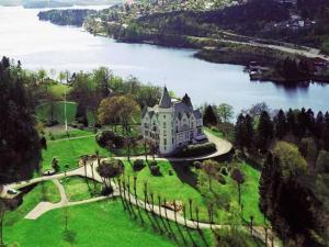 a large house on a field of grass next to a lake at Beautiful panorama fjord wiew 40 min from Bergen in Hamre