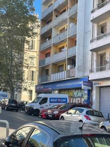 a parking lot with cars parked in front of a building at La petite Marseillaise in Marseille +3 photos