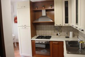a kitchen with white cabinets and a stove top oven at Pretty Favetti - lovely apartment in Trieste with a sea view - in Trieste
