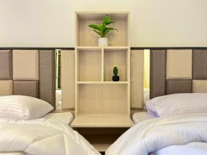 a bedroom with two beds and a plant on a shelf at Snow light 2BDR , Madinaty in Madinaty
