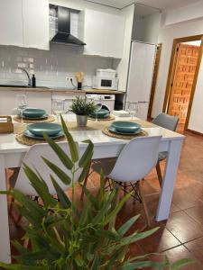 a kitchen with a table with green plates and chairs at La villa de Leo y Lola in Frómista