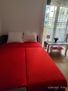 ein großes rotes Bett in einem Zimmer mit einem Tisch in der Unterkunft Hébergement tout confort dans logement proche de la gare in Montpellier