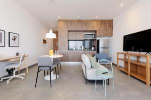 a living room with a couch and chairs and a kitchen at Be Grand by Wynwood House in Mexico City