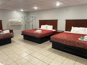 a hotel room with two beds with red sheets at PASCAGOULA EXTENDED STAY in Pascagoula