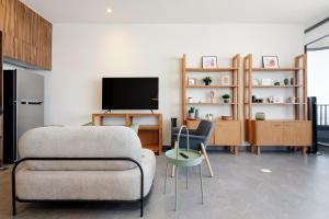 a living room with a couch and a tv at Be Grand by Wynwood House in Mexico City