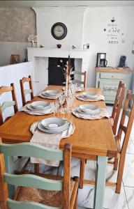 a wooden table with chairs and a dining room at Gîte Le Logis du Tilleul in Plassay