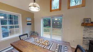 comedor con mesa de madera y ventanas en The Mendon House, en Killington