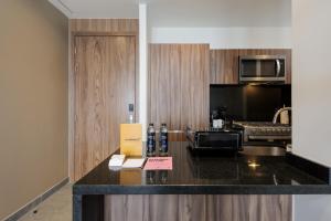 a kitchen with a counter with a microwave and a stove at Be Grand by Wynwood House in Mexico City +90 photos