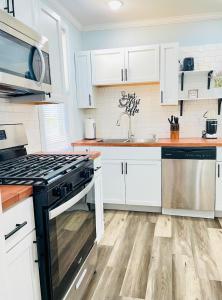 a kitchen with white cabinets and a stove top oven at Playground Fence near Beach Mall Casino in Michigan City
