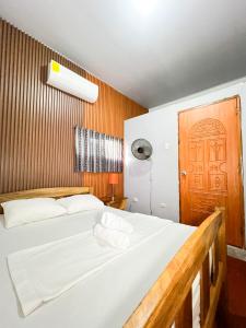 a bedroom with a bed and a wooden door at Surf Town Hostel in San Juan del Sur