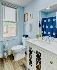 a bathroom with a toilet and a sink and a window at Playground Fence near Beach Mall Casino in Michigan City