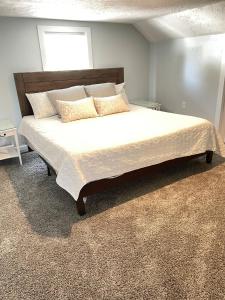 a bedroom with a large bed with white sheets and pillows at Playground Fence near Beach Mall Casino in Michigan City