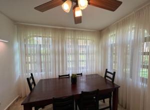 Una mesa de comedor con sillas y un ventilador de techo. en Condo 1bdr 1bth beach access, en Punta Cana