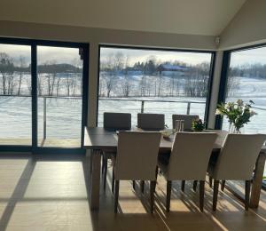 a dining room table with chairs and a large window at Peaceful rooms in a Modern and comfortable home in Asker
